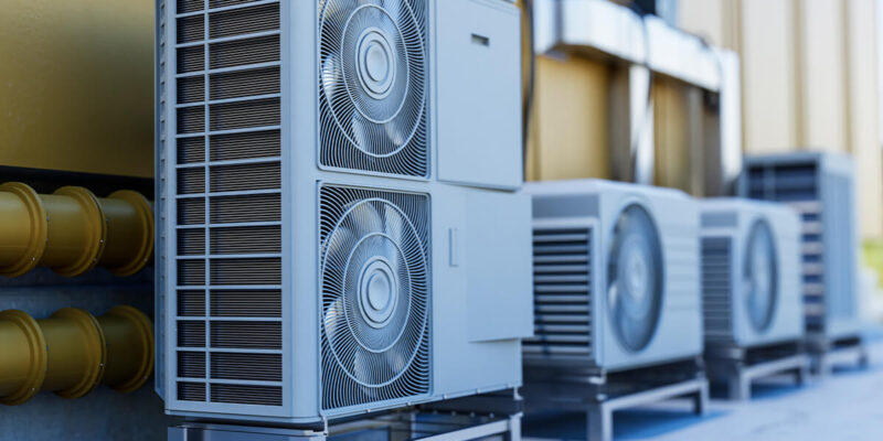 Graues Außengerät einer Klimaanlage mit zwei Ventilatoren auf einem stabilen Gestell.